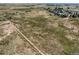 Expansive aerial view of a large parcel of land with scattered homes and agricultural fields in the distance at 3550 E 160Th Ave, Thornton, CO 80602