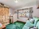 A quaint bedroom featuring a dormer window, a green sofa, and wooden furniture at 3550 E 160Th Ave, Thornton, CO 80602