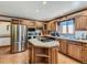 Well-lit kitchen with stainless steel appliances, a central island cooktop, and ample cabinet space at 3550 E 160Th Ave, Thornton, CO 80602