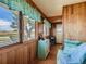 A relaxing sunroom featuring wood paneling, hardwood floors, and large windows overlooking the field at 3550 E 160Th Ave, Thornton, CO 80602