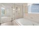 Bathroom featuring a tub shower with a glass enclosure and marble tile at 10890 Depew Pl, Broomfield, CO 80020