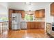 Modern kitchen with stainless steel appliances, wood cabinetry, and hardwood flooring at 10890 Depew Pl, Broomfield, CO 80020