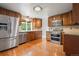 Updated kitchen featuring stainless steel appliances, wooden cabinets, and hardwood floors at 10890 Depew Pl, Broomfield, CO 80020
