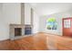 Bright living room features a brick fireplace, hardwood floors, and a large window at 10890 Depew Pl, Broomfield, CO 80020