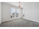 Bedroom with neutral carpet, three windows and a colorful chandelier at 12270 Karls Ln, Northglenn, CO 80241