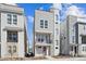 Modern three-story home with a balcony, stylish stonework, and neutral-colored siding at 12270 Karls Ln, Northglenn, CO 80241