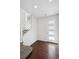 Bright foyer with hardwood floors, leading to a staircase with modern white railings and a door with frosted windows at 12270 Karls Ln, Northglenn, CO 80241