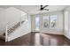 Bright living room with hardwood floors, staircase, ceiling fan, and large windows that fill the room with natural light at 12270 Karls Ln, Northglenn, CO 80241