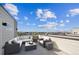 Relaxing rooftop deck featuring stylish outdoor furniture and expansive views of the surrounding neighborhood under a bright sky at 12270 Karls Ln, Northglenn, CO 80241