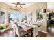 Bright dining room with large windows and rustic farmhouse table and elegant seating at 3336 White Oak Ln, Highlands Ranch, CO 80129