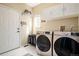 Functional laundry room featuring modern washer/dryer, storage cabinets, and tiled floors at 3336 White Oak Ln, Highlands Ranch, CO 80129