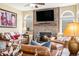 Cozy living room with a stone fireplace, plush leather seating, and lots of natural light at 3336 White Oak Ln, Highlands Ranch, CO 80129