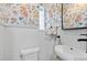 Small bath with modern sink and fixtures featuring unique wallpaper at 561 Cook St, Denver, CO 80206