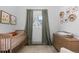 Bright Bedroom featuring a wooden crib, window with tree-top views, and plant decor at 561 Cook St, Denver, CO 80206