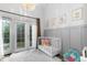 Bright Bedroom featuring a cozy crib, unique chandelier, and private patio access at 561 Cook St, Denver, CO 80206