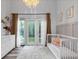 Sunny Bedroom showcasing patio access, white dresser, and stylish overhead lighting at 561 Cook St, Denver, CO 80206