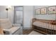 Charming Bedroom features wooden crib, cozy chair, and unique glass-block window to the ensuite at 561 Cook St, Denver, CO 80206