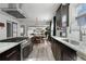 Modern kitchen with stainless steel appliances and dark cabinets, transitions into dining and living space at 561 Cook St, Denver, CO 80206