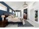 Chic main bedroom featuring dark blue accent wall, a chandelier, ensuite bath, and ample natural light at 561 Cook St, Denver, CO 80206