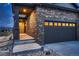 Well-lit home exterior with a stone facade and two-car garage, showcasing the welcoming entrance and landscaping at 3703 New Haven Cir, Castle Rock, CO 80109
