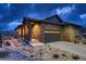 Charming home exterior at twilight showcasing a stone facade, attached garage, and well-manicured landscaping at 3703 New Haven Cir, Castle Rock, CO 80109