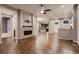 Open-concept living room featuring hardwood floors and a brick fireplace, transitioning into the adjacent kitchen at 3703 New Haven Cir, Castle Rock, CO 80109