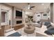 Inviting living room with a brick fireplace and modern ceiling fan, seamlessly flowing into the open kitchen at 3703 New Haven Cir, Castle Rock, CO 80109