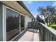 Relax on this covered balcony, which offers views of the lawn, mature trees, and a clear blue sky at 2150 S Vaughn Way # 302D, Aurora, CO 80014