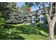 Charming multi-story condo building with green balconies, well-maintained landscaping, and mature trees at 2150 S Vaughn Way # 302D, Aurora, CO 80014