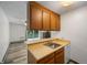 Cozy kitchen featuring wood cabinets, a stainless steel sink, and an adjacent living area with a fireplace at 2150 S Vaughn Way # 302D, Aurora, CO 80014