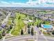 An aerial view of the community featuring green park space with a pool, walking paths, and playground at 5826 S Jebel Way, Centennial, CO 80015