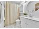 Bathroom with white vanity, round mirror, and shower with tan-colored curtain at 5826 S Jebel Way, Centennial, CO 80015