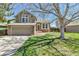 Charming two-story home boasts a well-manicured lawn, mature tree, and attached two-car garage at 5826 S Jebel Way, Centennial, CO 80015
