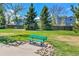 Park features include a green bench with landscaping of rocks and a walking path on the lawn at 5826 S Jebel Way, Centennial, CO 80015