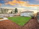 This fenced backyard features a manicured lawn, wood mulch, and a lush green backdrop for outdoor enjoyment at 3630 Magnolia St, Denver, CO 80207