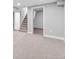 Spacious basement area with neutral carpet and walls, leading to a stairwell and storage space at 3630 Magnolia St, Denver, CO 80207