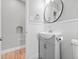 Well-lit bathroom features a modern sink, round mirror, and charming white wainscoting at 3630 Magnolia St, Denver, CO 80207