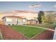 Quaint single-story home featuring lush green grass, a tidy yard, and a charming light-blue front door at 3630 Magnolia St, Denver, CO 80207