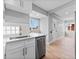 Bright kitchen with white cabinets, stainless steel dishwasher, and a view into the adjacent living room at 3630 Magnolia St, Denver, CO 80207