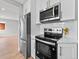 Modern kitchen featuring stainless steel appliances, white cabinets, and light wood flooring at 3630 Magnolia St, Denver, CO 80207