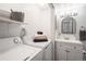 Efficient laundry area with stacked washer and dryer, storage shelves, and an adjacent bathroom with updated fixtures at 14751 E Tennessee Dr # 228, Aurora, CO 80012