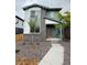 Charming two-story home with gray stone and colorful exterior featuring a red door and rock landscaping at 21011 E 63Rd Dr, Aurora, CO 80019