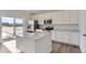 Bright kitchen featuring white cabinetry, stainless steel appliances, and an island with quartz countertops at 16622 E 109Th Ave, Commerce City, CO 80022