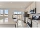 Modern kitchen showcasing white cabinets, quartz countertops, stainless steel appliances, and backyard views at 16622 E 109Th Ave, Commerce City, CO 80022