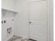 Functional laundry room with white shelving, tiled floors, and utility connections at 16622 E 109Th Ave, Commerce City, CO 80022