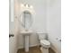 A pristine powder room with a pedestal sink, oval mirror and a white toilet at 24709 E 39Th Ave, Aurora, CO 80019
