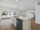 A bright kitchen featuring white cabinets, a large island, stainless steel appliances, and wood flooring at 24709 E 39Th Ave, Aurora, CO 80019