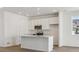 Modern kitchen features stainless steel appliances, white cabinets, and an island with sink at 24709 E 39Th Ave, Aurora, CO 80019