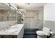 Modern bathroom with a double sink vanity, sleek toilet, and a glass-enclosed shower at 8 Lindenwood Dr, Littleton, CO 80120