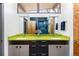 Bright bathroom featuring a double sink with modern fixtures, stylish green countertop and natural light at 8 Lindenwood Dr, Littleton, CO 80120